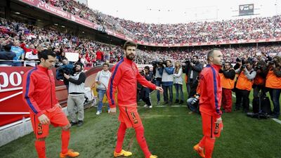 Gerard Pique, centre, was at fault for Sevilla's equaliser as Barcelona were held to a draw after leading 2-0. Marcelo del Pozo / Reuters