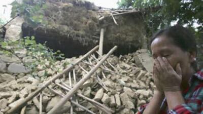 Zhang Mingyu, 41, cries in front of her house, which was destroyed during an aftershock in Yuanmou County, Yunnan province, on Sunday.
