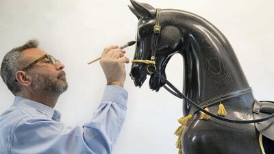 Rocking-horse artist Matthew Clift adds the final touches to a black arab rocking horse at the Stevenson Brothers rocking horse makers workshop in the village of Bethersden, near Ashford, United Kingdom. Stephen Lock for the National