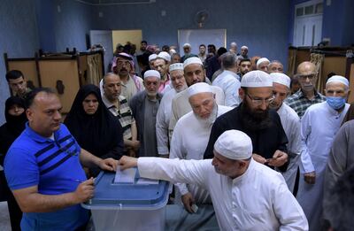 Syrians casts their ballots at a polling station in Aleppo on May 26, 2021 as voting began across Syria for an election guaranteed to return President Bashar Al Assad for a fourth term in office. AFP