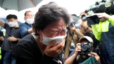 A woman mourns as the hearse carrying late Seoul Mayor Park Won-soon leaves Seoul City Hall Plaza after his funeral in South Korea. Reuters
