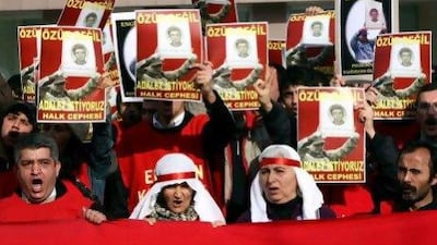 Family members and friends hold up posters of political activist Engin Ceber. A prison director and two guards have been convicted for their involvement in his torture and death in custody.