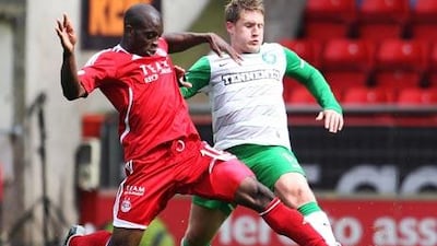 Aberdeen's Issac Osbourne, left, and Celtic's Kris Commons battle for the ball in front of empty seats.