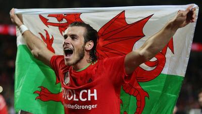 Gareth Bale of Wales celebrates with the Welsh flag after their final Euro 2016 qualifying match on Tuesday night. Matthew Childs / Action Images / Reuters