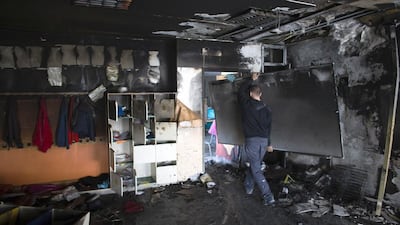 A worker carries a burnt board in a torched classroom in an Arab-Jewish school in Jerusalem on November 30, 2014. Suspected Jewish extremists set fire to the classroom targeting a symbol of co-existence in a city on edge over a recent surge in violence, police said. Ronen Zvulun/Reuters