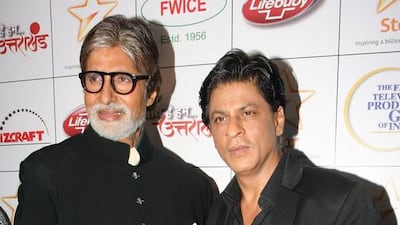 Indian Bollywood actor Amitabh Bachchan (L) and Shah Rukh Khan pose for the media as they attend a fundraiser event for the "Saath Hain Hum Uttarakhand" following the June flash floods in the northern Indian state that killed thousands, in Mumbai on August 15, 2013. AFP PHOTO/STR