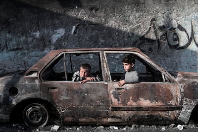 Children sit in a destroyed car in the southern Gaza Strip. AFP