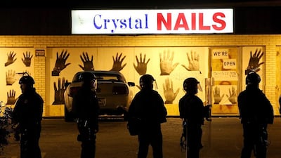 Police officers form a line up in front of a nail salon as they clear protestors from the street during a demonstration on Monday in Ferguson. Justin Sullivan / Getty Images / AFP