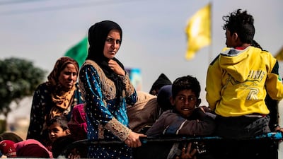 Displaced Syrians sit in the back of a pick-up truck as Arab and Kurdish civilians flee amid Turkey's military assault on Kurdish-controlled areas in northeastern Syria. AFP