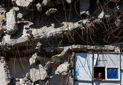 A Palestinians looks out from a window amid the rubble of a building destroyed during the war, at the Jabalia refugee camp in the northern Gaza Strip. Reuters