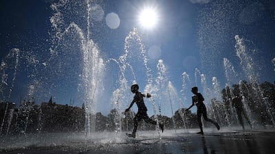 Children cool off as they run through a public fountain in Colmar, eastern France. AFP