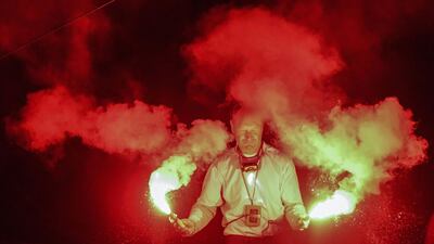 French skipper Francis Joyon celebrates with flares onboard his Ultim multihull IDEC Sport off the coast of Pointe-a-Pitre on Guadeloupe after winning the Route du Rhum solo sailing race. AFP