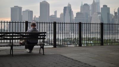 A man sits in the Brooklyn Heights Promenade overlooking the Manhattan skyline, in New York City. More apartment buyers are taking advantage of new bargaining power as prices decline in the New York City borough. AFP