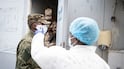 A staff in protective gown checks visitor’s temperature as a preventive measure against Ebola in the Democratic Republic of Congo. EPA.
