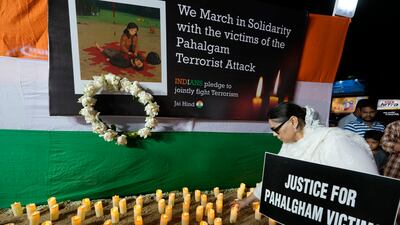 A woman in Kolkata places a candle during a protest against the killings. AP