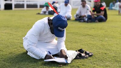 A man fills in his card at Meydan. Reem Mohammed / The National
