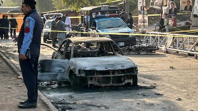 Police examine damaged vehicles after a suicide blast outside the district court in Islamabad on Tuesday. AFP