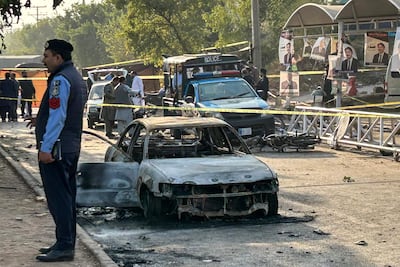 Police examine damaged vehicles after a suspected suicide bombing outside the district court in Islamabad on November 11 that killed 12 people. AFP