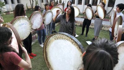 Young Yazidi and Muslim women, part of the musical group "40 Plaits," rehearse a traditional Kurdish song accompanied by the Daf, a large Kurdish frame drum, in a community centre in Dahuk, about 260 miles (430 kilometers) northwest of the Iraqi capital Baghdad. AFP