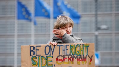 A climate change activist holds a sign during a protest in front of the European Council to call the EU for an immediate embargo on Russian oil and gas. Reuters.