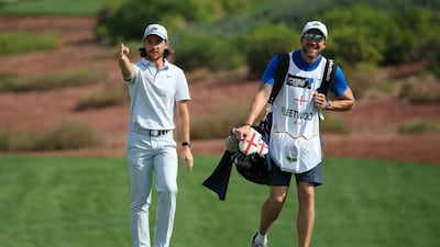 Tommy Fleetwood of England walks with his caddie on the first fairway. Getty