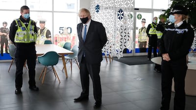 Boris Johnson meets police officers who deal with Covid rule enforcement, during a visit to South Wales Police headquarters in Bridgend, Wales. AP Photo