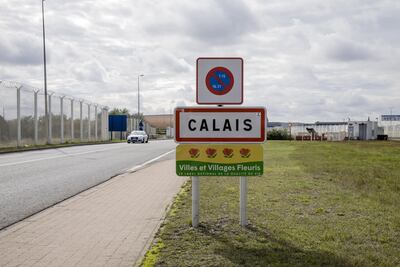 A sign for the city of Calais stands near a barbwire security fence on a road leading to the Port of Calais. Bloomberg