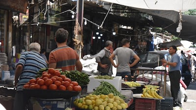 Syrians shop for vegetables at a market in Damascus on Sunday July 11, hours after Syrian President Bashar Al Assad issued a legislative decree granting civil servants and military members a 50 per cent pay rise. The decision comes a day after the government raised the price of fuel by more than 50 per cent for the third time this year. EPA
