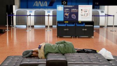 A man sleeps next to an airline counter at the domestic terminal of Haneda Airport, after flights were suspended due to Typhoon Hagibis in Tokyo, Japan. Reuters
