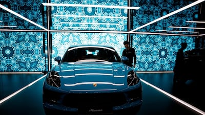 A visitor looks at a Porsche Macan. EPA