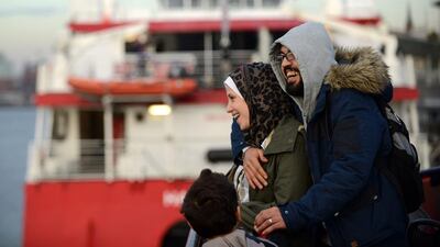 Syrian refugees Wael Al Awis, 31, right, embraces his wife Reem Haskour, 30, while their son Ali Al Awis, 6, watches during a visit at the harbour in Hamburg, Germany. The family was reunited three weeks ago after Reem and Ali made it to Germany following an arduous journey. The two rode a small inflatable rubber boat from Turkey to Greece, then continued their trek via the Balkans, Hungary and Austria before finally reaching Germany and Hamburg by train. Astrid Riecken / Getty Images