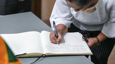 A woman signs the condolence book.