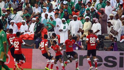 Al Ahli players rally around Grafite, centre, to celebrate the goal with the disappointed Shabab supporters in the background. Satish Kumar / The National