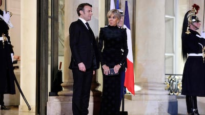 Mr Macron and his wife Brigitte wait for the arrival of Sheikh Tamim. AFP