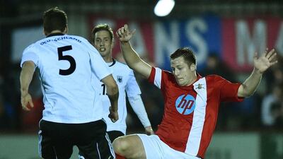 British Army player Calum Wilkinson, right, dives at the ball against German Army (Bundeswehr) player Michal Kniat in the match called the "Game of Truce" on Wednesday. Ben Stansall / AFP