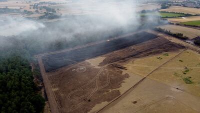 Burnt woodland is seen as smoke rises from the trees following a fire in Blidworth. Getty Images