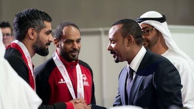 Mr Ahmed greets an athlete during the Special Olympics World Games Abu Dhabi 2019 as Sheikh Mohamed bin Zayed looks on.