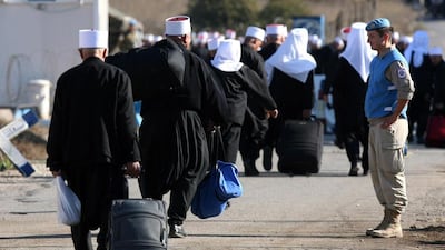 UN soldiers watch Druze men from the Golan heights as they cross to Syria for religious occasion. Atef Safadi / EPA