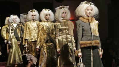 Designer Thom Browne filled a gallery space with real church pews, put huge crosses on the wall, and lit candles and incense. Models with freaky white wigs walked stiffly down the runway, AP