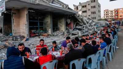 Palestinian families break their fast next to a destroyed building during recent confrontations between Hamas and Israel in the Gaza Strip. AFP