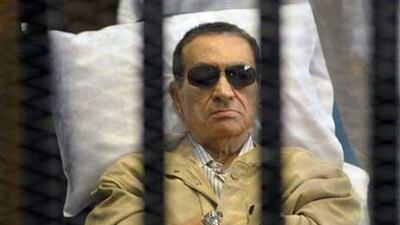 Egypt's ex-President Hosni Mubarak lies on a gurney inside a barred cage in the police academy courthouse in Cairo, during a hearing in which he was sentenced to life in prison.