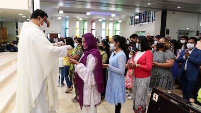 Father Andre gives communion at St Mary's Catholic Church Dubai. Pawan Singh / The National