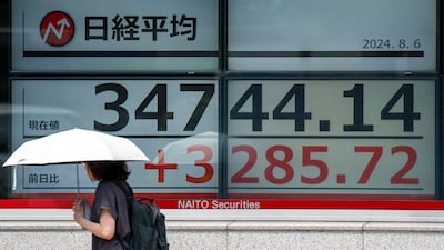 An electronic board displays Tokyo Stock Exchange prices. The Nikkei rose by about 10 per cent in early trade on Tuesday. AFP