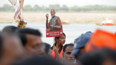 A young Indian girl holds up a placard bearing the portrait of Indian prime minister-elect Narendra Modi ahead of his arrival in Varanasi, India. Manjunath Kiran / AFP