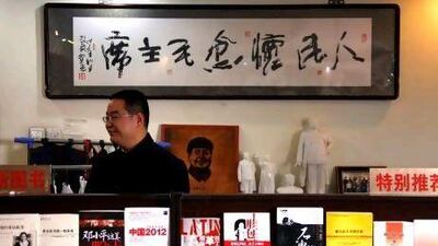 Fan Jinggang, the general manager of the neo-Maoist "Utopia" website and bookstore, stands in front of small statues of the former Chinese leader Mao. Mr Fan says China has turned its back on the ideals on which it was founded.