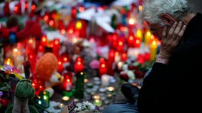 A man looks at flags, messages and candles placed yesterday in memory of the victims of the van attack in Barcelona. Manu Fernandez / AP