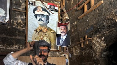 A Yemeni man stands beneath posters of former president Ali Abdullah Saleh in Sana’a, Yemen. Reports state that a United Nations team of experts on the sanctions committee in Yemen suspect five individuals of obstructing the transitional process in Yemen, including former president Ali Abdullah Saleh, his son, Ahmed. Yahya Arhab / EPA