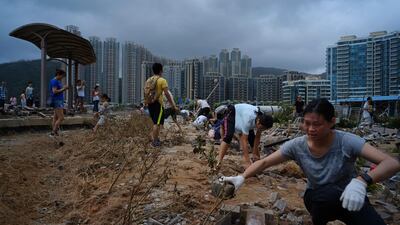People clean debris from Typhoon Mangkhut on the waterfront in Hong Kong. AP Photo