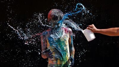 A boy smeared with colours reacts as another boy pours water on him during Holi celebrations in Chennai. Babu / Reuters