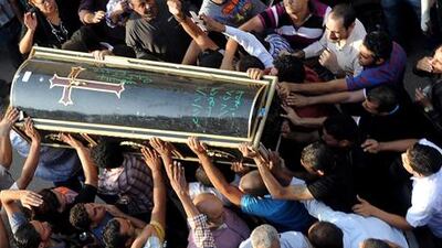 Egyptian Coptic Christians gather next to the coffin of one of the protesters killed during clashes the day before.